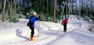 A couple cross country skis in a Minneapolis park during a bright, sunny day.