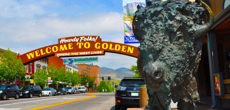 A buffalo statute and large arch over the street welcome people to Golden, CO.