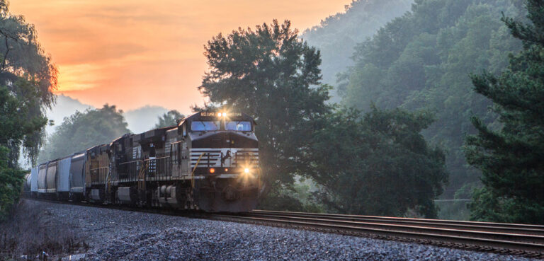 A train cuts through the wilderness during sunrise in West Virginia.