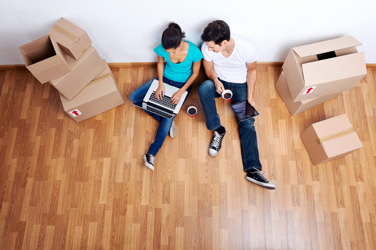 Couple on the floor with moving boxes around them.
