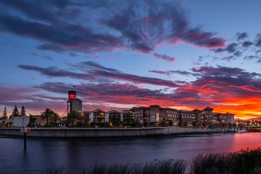 A view of the downtown riverfront during sunset, which produces an orange glow in Napa, California.
