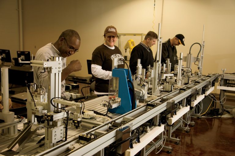 Students work with robots on a small scale production line at Wilkes Community College in Wilkesboro, NC.