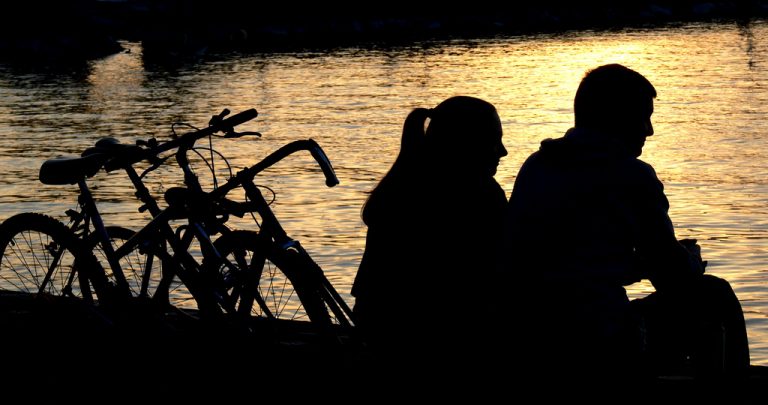 Couple on date with bicycles by lake
