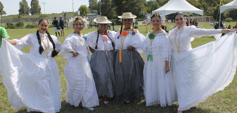 Ladies in white dresses pose for a picture at the Hispanic Heritage Festival