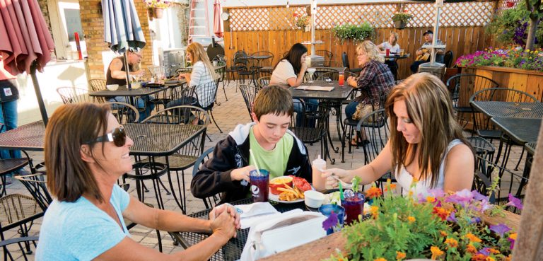 Two women and a boy eat outside at the Drift Inn in Rupert, ID.