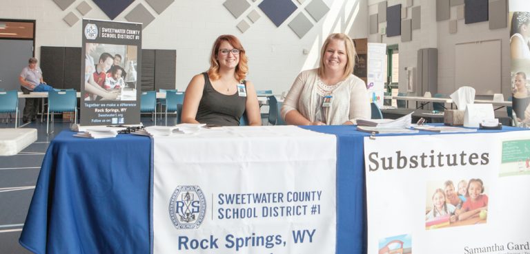 Samantha Gardner and Kandi Hess set up to recruit new substitute teachers for the new school year.