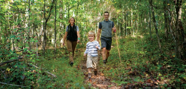 A couple and their young son hike in Haw Ridge Park