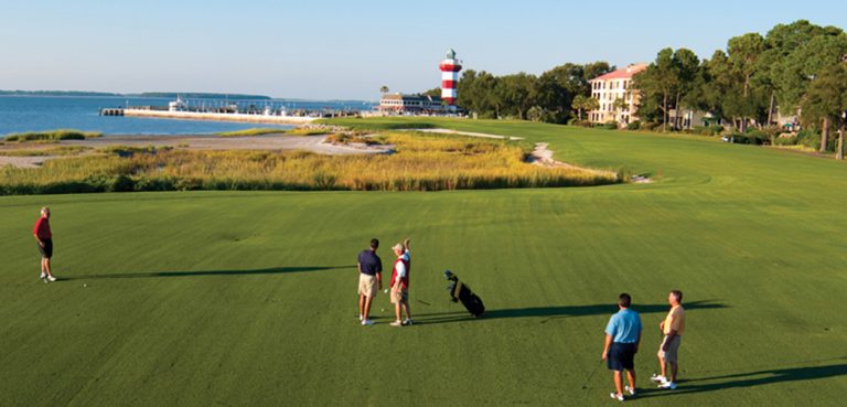 Five men golf in front of a lighthouse on the Harbour Town Course in Hilton Head, SC.