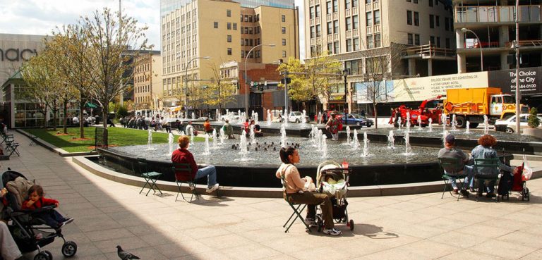 People with children gather around a fountain in White Plains, NY.