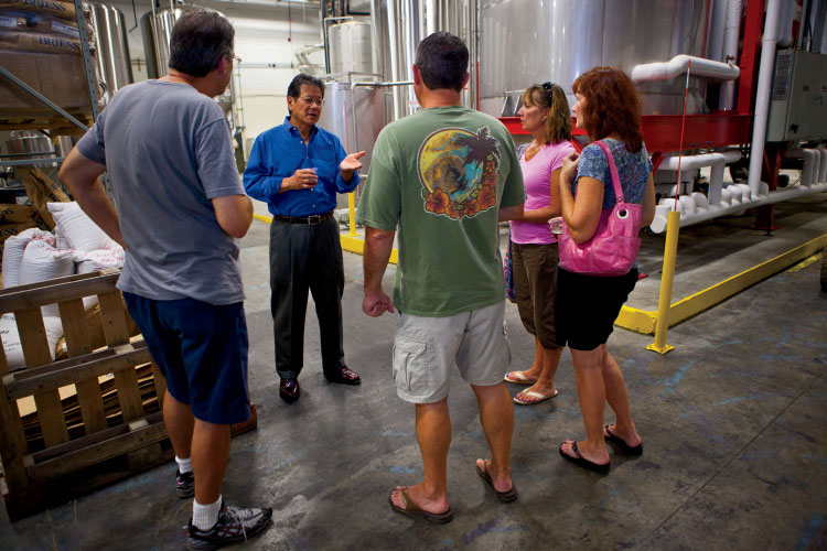 Highland Brewing Company owner Oscar Wong (blue shirt) gives a brewery tour to visitors at Highland Brewing Company in Asheville
