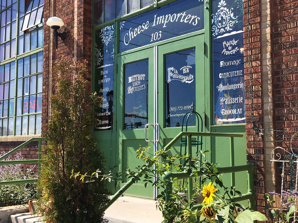Exterior shot of Cheese Importers in Longmont, Colorado. The business has been around since 1976 and is a combination of French bistro, European-inspired marketplace and epic cheese shop all in one.