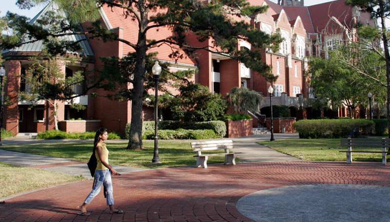 A female college student walks across campus at the University of Florida.