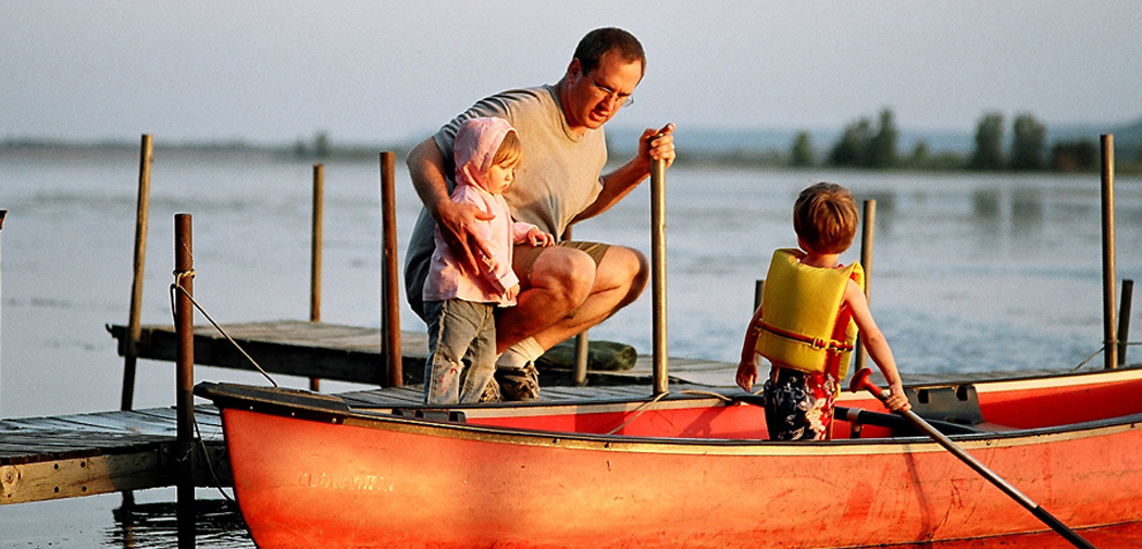 A dad and his kids canoe on the waters of Onalaska, Wisconsin.