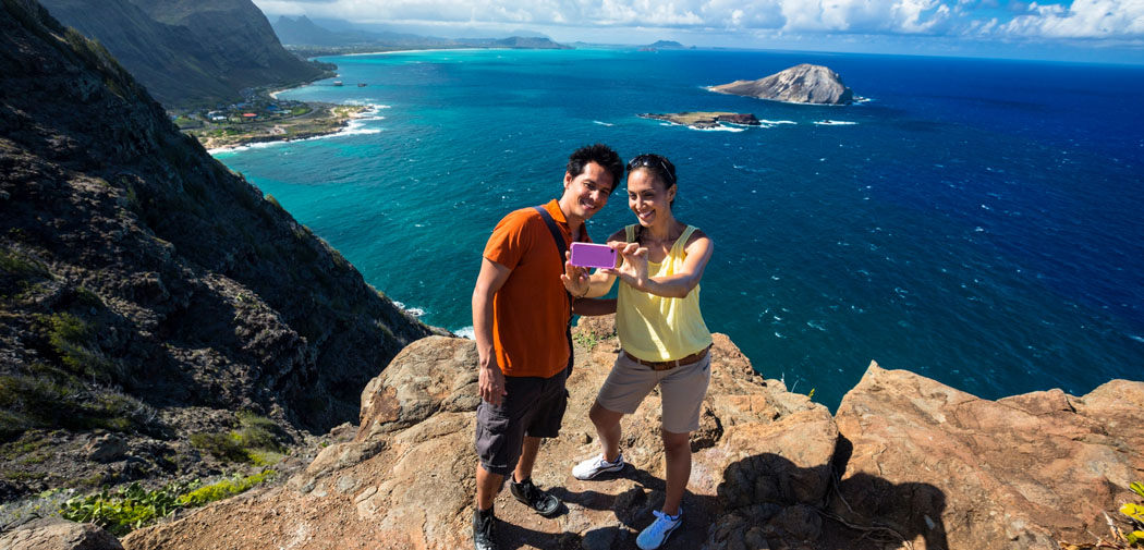 Couple takes a photo at the top of Makapuu in Honolulu, Hawaii.