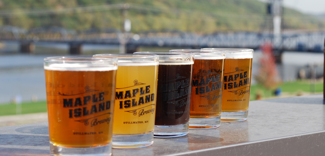 A flight of beer from Maple Island Brewing on display with the Lift Bridge in the background.