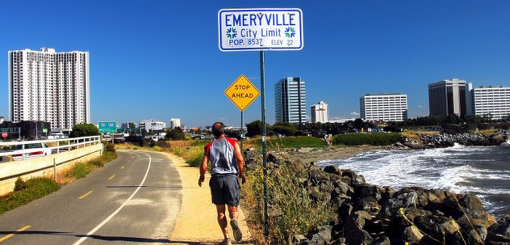 A runner jogs a trail along the road in Emeryville, California.