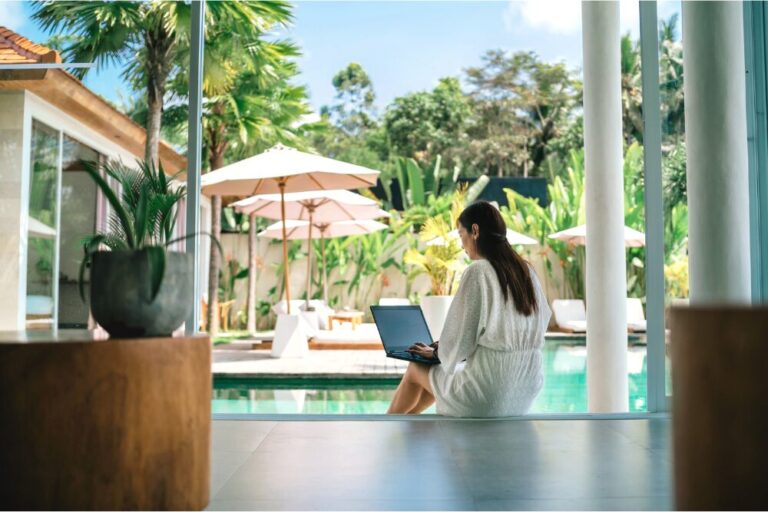 Woman working with laptop at poolside stock photo