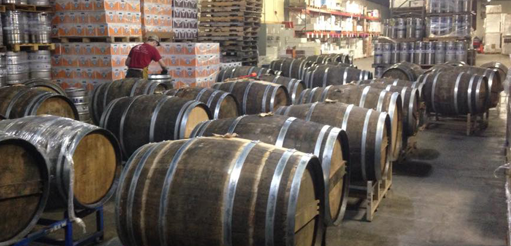 A man caps a barrel in the warehouse at Clown Shoes Brewing Co.
