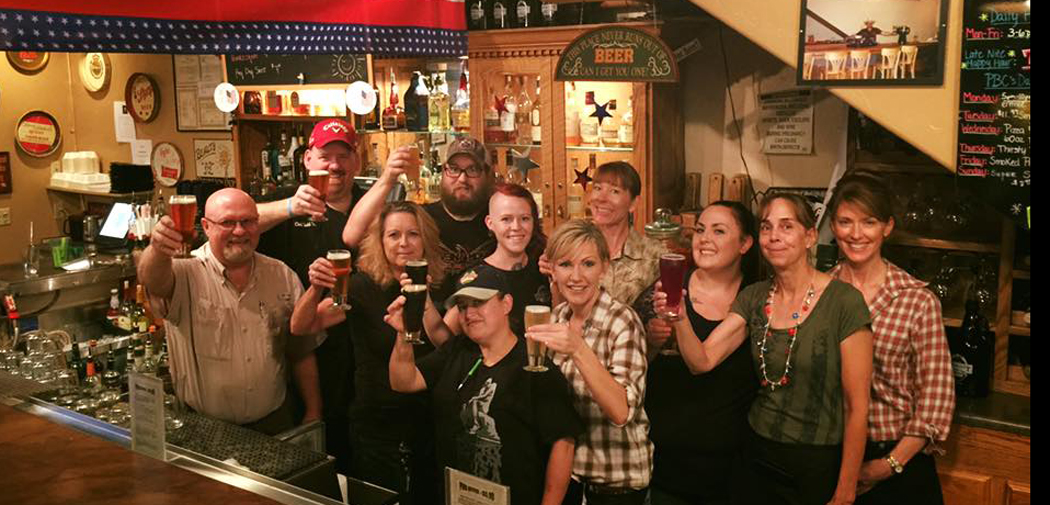 People at Prescott Brewing Company raise a glass to toast fellow drinkers.