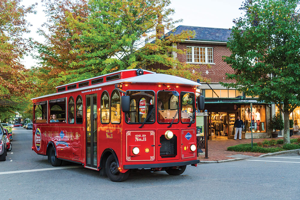 Red trolley driving through downtown Asheville
