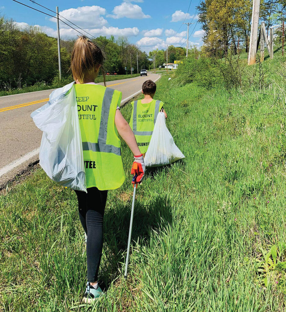 volunteers pick up trash along road