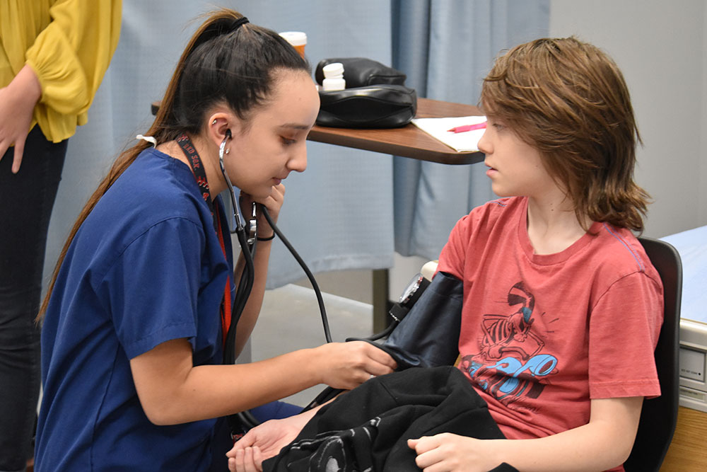Nursing student checking child's blood pressure