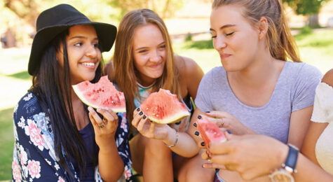 teenage girls eating watermelon