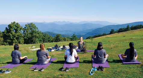 Women doing yoga on a mountain