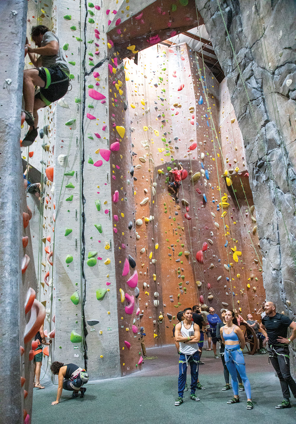 Rock climbers scale wall at indoor facility