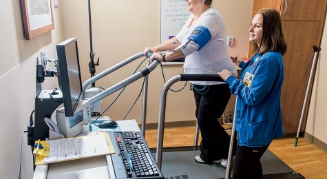 nurse works with patient on treadmill