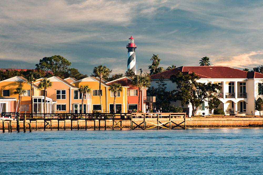 Old Lighthouse and colorful dockside on cloudy sky background in Florida's Historic Coast