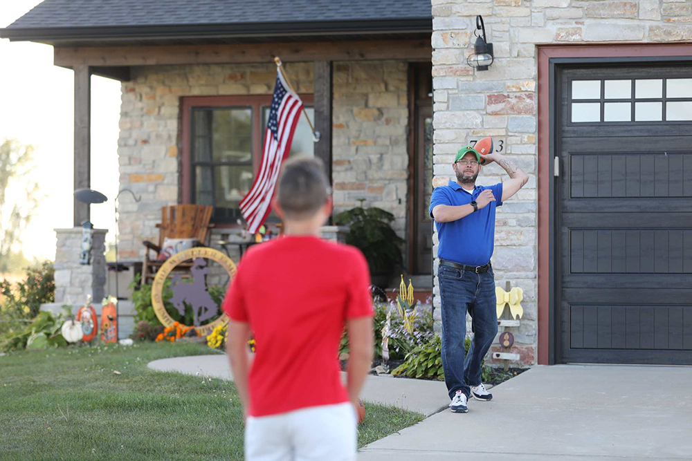 Charles “C.J.” Wheeler plays with his sons in front of his home he found with the help of Home Base Iowa in Eldridge. ©Journal Communications/Nathan Lambrecht