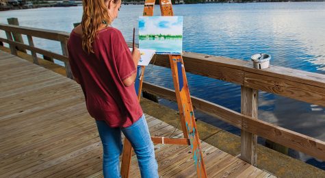 A woman paints along the waterfront in Elizabeth City, NC.