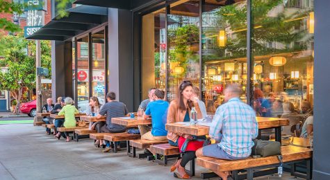 People dine on a restaurant patio in downtown Portland Oregon USA in the evening.