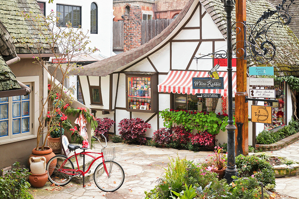 A streetscape in Carmel-by-the-Sea featuring a retail shop housed in a typical fairytale cottage - style architecture. Carmel located on the Monterey Peninsula was founded in 1902 and is known for its natural scenery and artistic history.