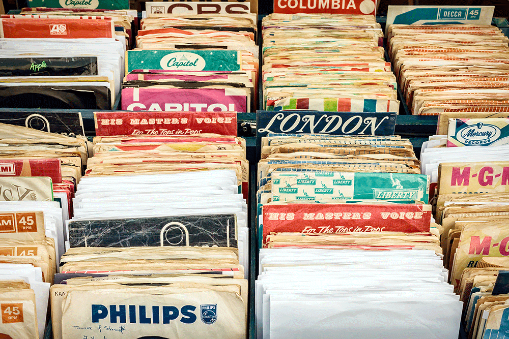 Wooden boxes with vinyl turntable records at a flee market. 