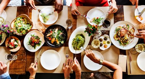 Overhead shot of a farmhouse style table of people eating dinner