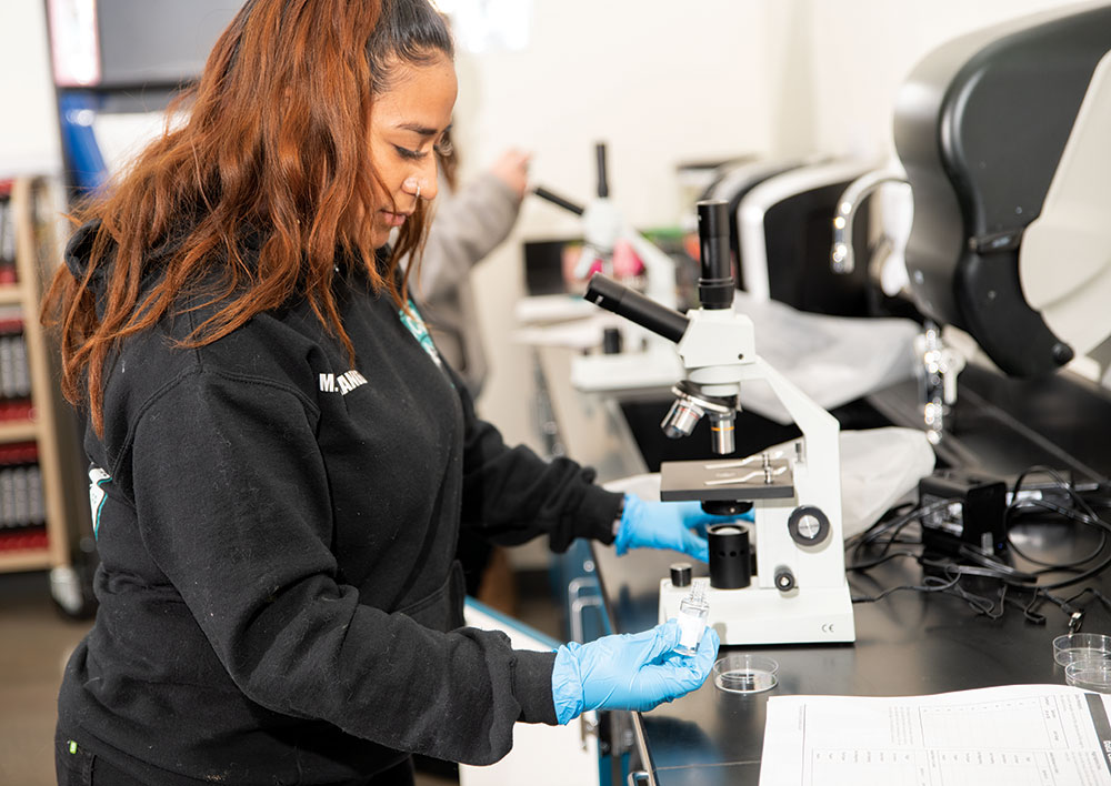 Makaila Hernandez prepares a microscope during a CSI class at the FutureForward at Washington Square career and technical education campus in Thornton, CO.