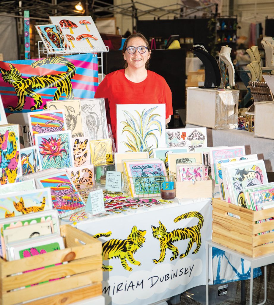 Miriam Dubinsky sells prints during an artisans’ fair at the Stanley Marketplace in Aurora, CO.