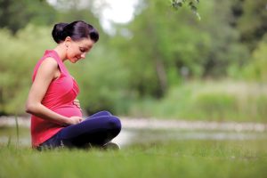 Young pregnant woman relaxing at a park