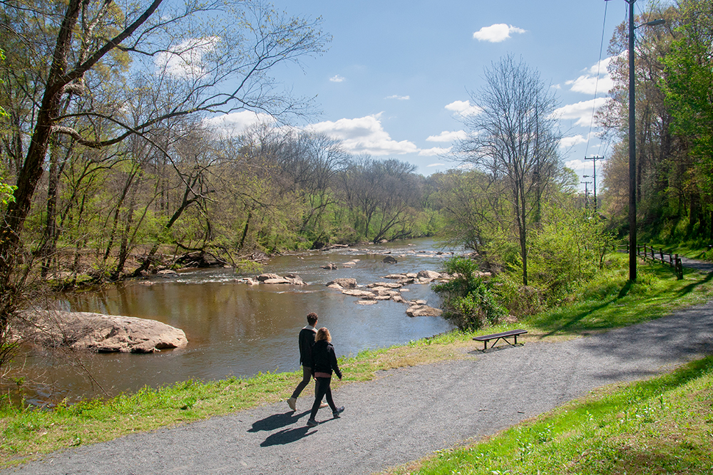 People walking along the water at Randleman Deep River State Trail in Asheboro, NC.