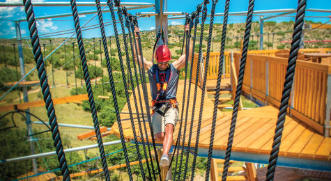 Castle Rock, CO: Person goes across a ropes course zipline at The EDGE Ziplines and Adventures