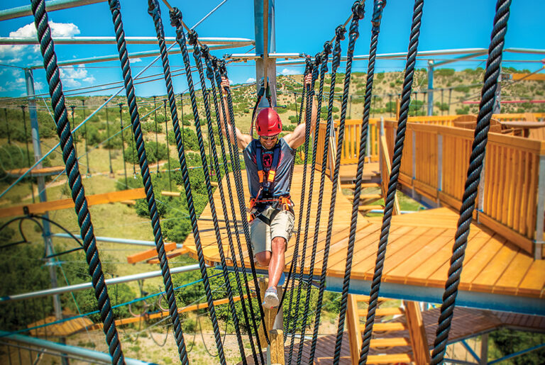 Castle Rock, CO: Person goes across a ropes course zipline at The EDGE Ziplines and Adventures