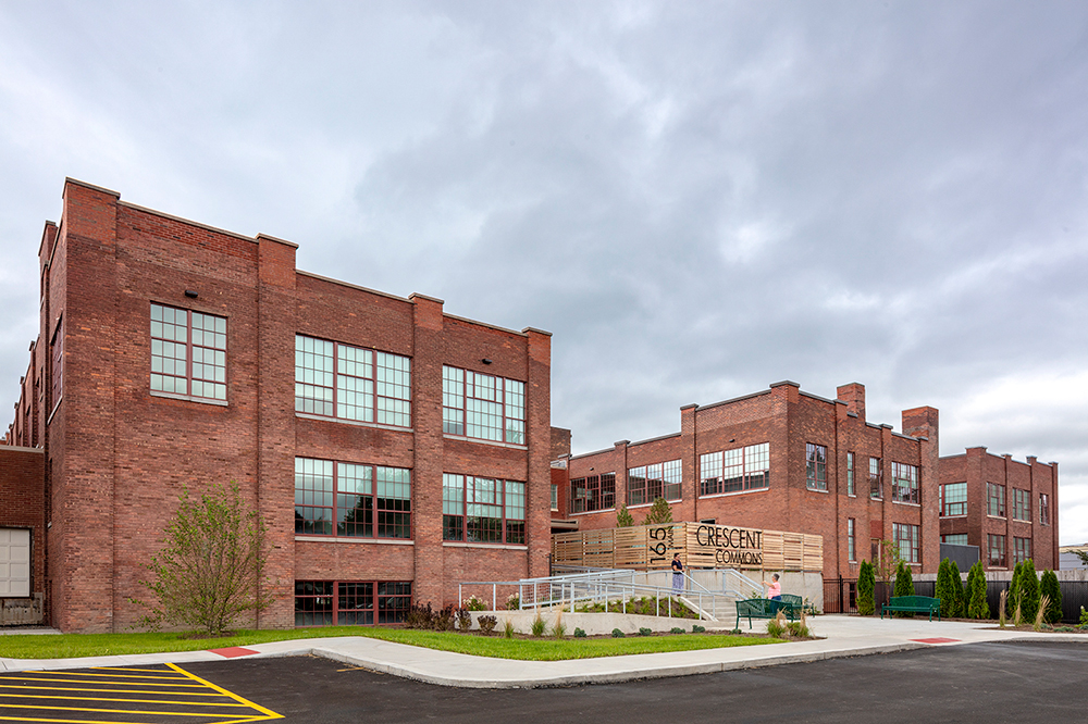 An exterior shot of Crescent Commons, a repurposed, mixed-use building in Cortland, New York. 