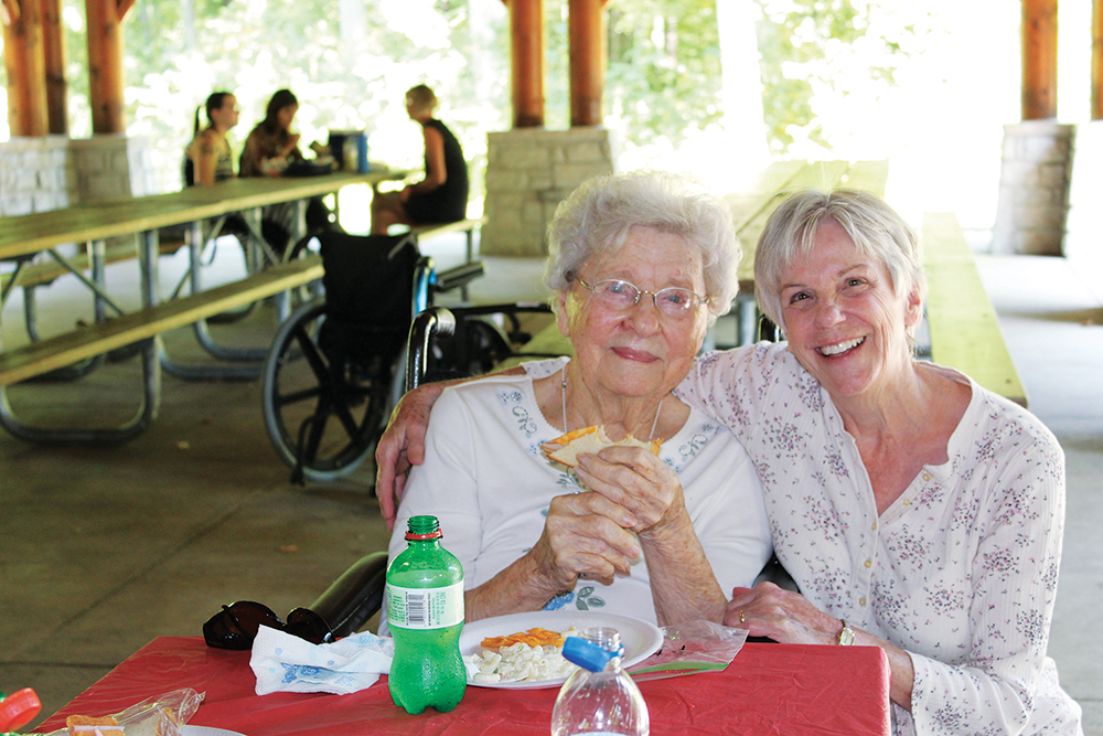 Two women enjoying lunch outdoors at and are residents at The Carlyle House Assisted Living in Dayton, OH.