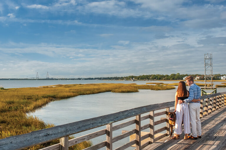 Couple and their dog look out at the water at  Pitts Street Bridge in South Carolina.
