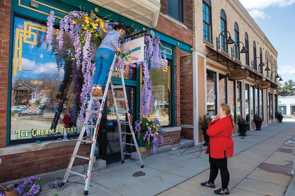Heidi Rossiter, left, decorates The Sugar Exchange for Spring while talking with owner Courtney Perakis in downtown Janesville, part of the Greater Madison Region.