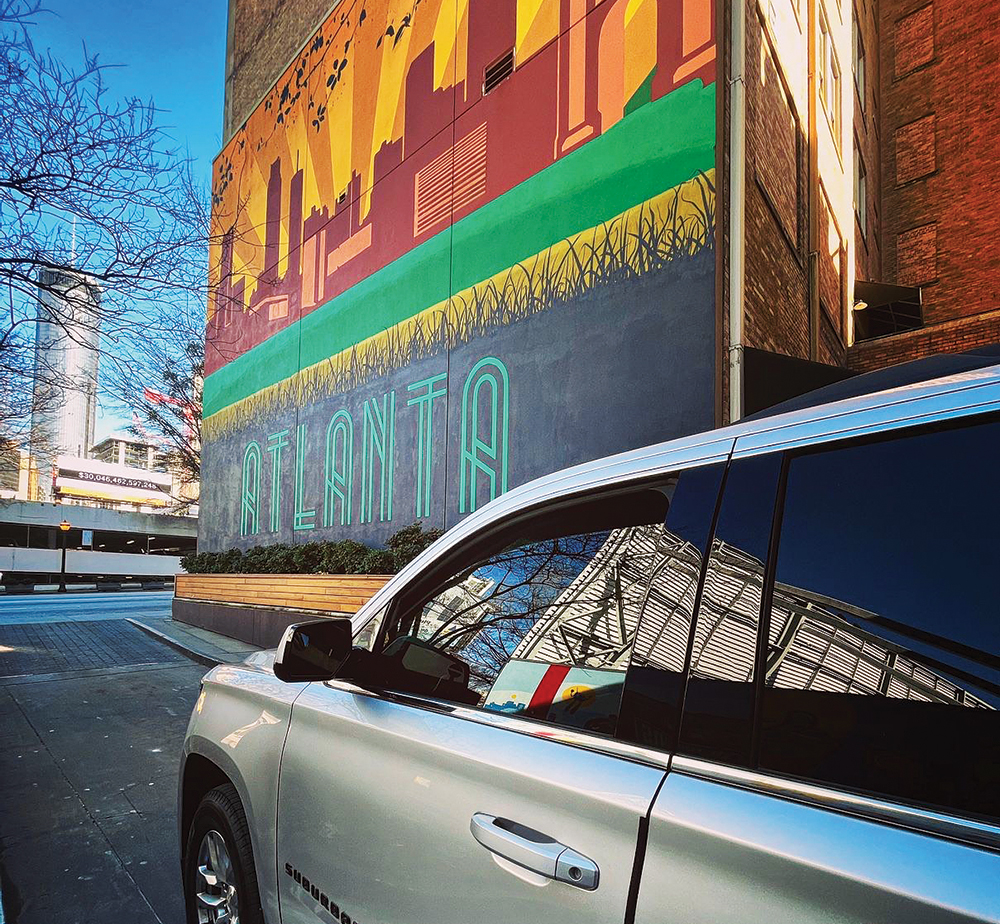 A Middle Georgia Luxury Transportation car parked outside of a mural in Atlanta, GA, which is just outside of the Robins Region area of Georgia.