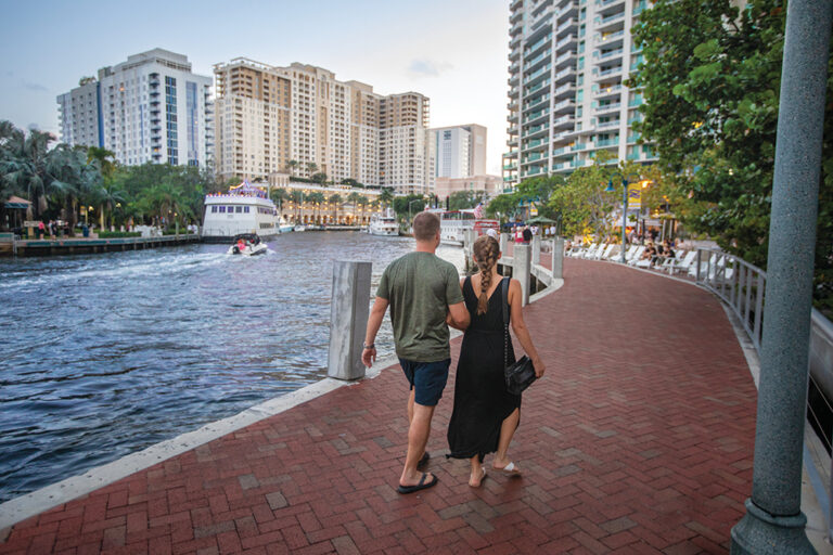Visitors stroll along the New River at Riverwalk Fort Lauderdale in downtown Fort Lauderdale, Florida.