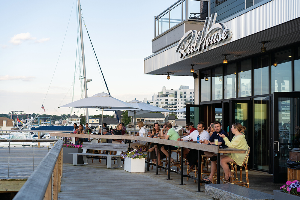 People dine on the patio at Reel House, which is located at the Safe Harbor Marina in Quincy, MA.